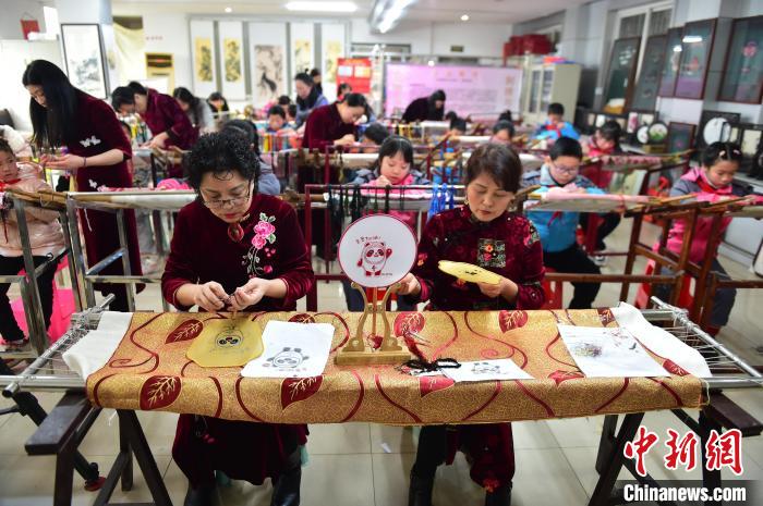 江西省級(jí)非遺豫章繡傳承人手把手指導(dǎo)小學(xué)生繡制2022年北京冬奧會(huì)吉祥物“冰墩墩”形象?！∮髟屏?攝