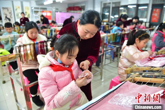 江西省級(jí)非遺豫章繡傳承人手把手指導(dǎo)小學(xué)生繡制2022年北京冬奧會(huì)吉祥物“冰墩墩”形象?！∮髟屏?攝