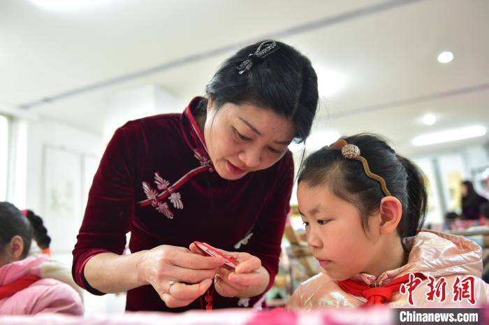 江西省級(jí)非遺豫章繡傳承人手把手指導(dǎo)小學(xué)生繡制2022年北京冬奧會(huì)吉祥物“冰墩墩”形象?！∮髟屏?攝