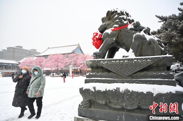 2月13日，民眾在呼和浩特市大召廣場雪中漫步?！⑽娜A 攝