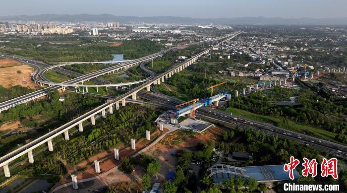 航拍正在建設(shè)的跨越成都繞城高速公路連續(xù)梁施工現(xiàn)場(chǎng)，旁邊依次為已運(yùn)營(yíng)的成渝高速鐵路和機(jī)場(chǎng)高速公路?！⒅铱?攝