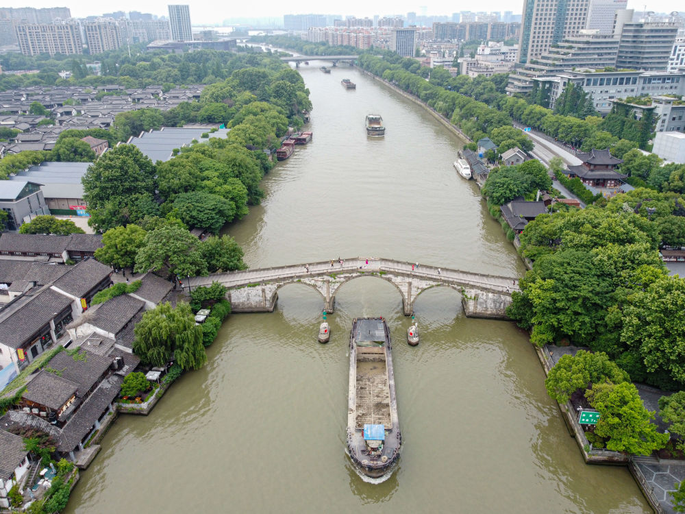 5月27日，一艘貨船駛過京杭大運(yùn)河南端標(biāo)志建筑杭州拱宸橋。(無人機(jī)照片)新華社記者江漢 攝