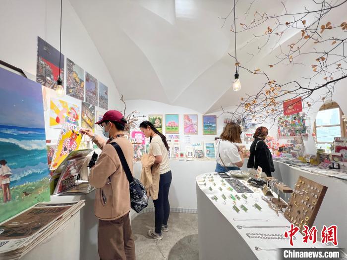 圖為藝術品商店內，顧客挑選插畫作品?！＄婌?攝