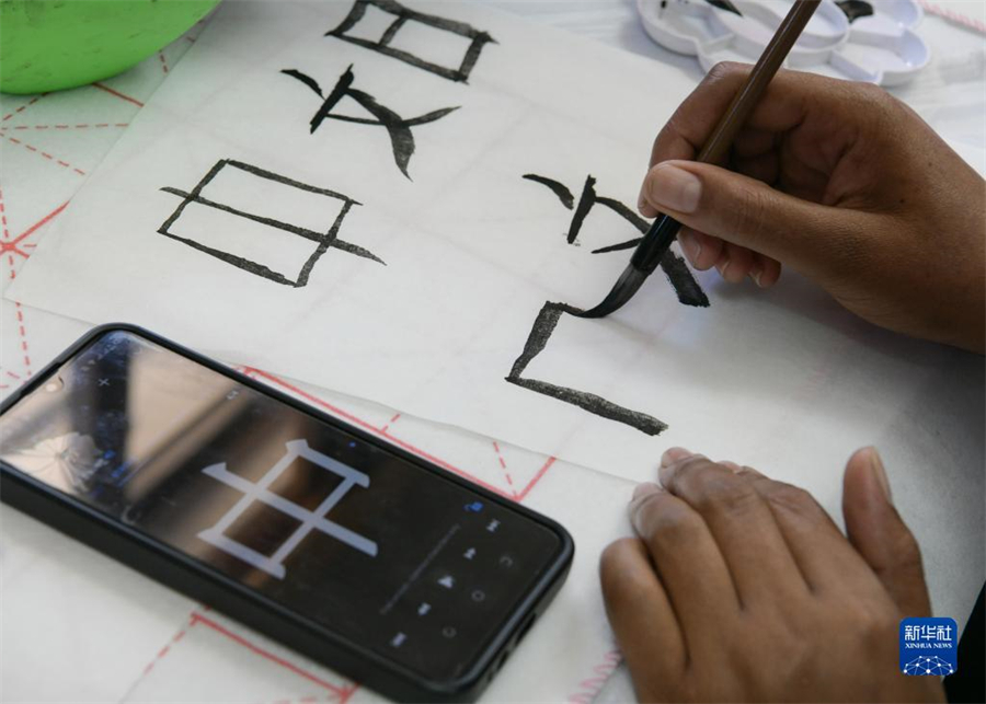 4月18日，肯尼亞學(xué)生在內(nèi)羅畢大學(xué)孔子學(xué)院舉辦的活動上寫毛筆字?？夏醽唭?nèi)羅畢大學(xué)孔子學(xué)院18日舉辦“中文，增進(jìn)文明對話”主題活動，慶祝即將到來的第14個聯(lián)合國中文日。肯尼亞學(xué)生參與互動，進(jìn)行書法、剪紙、唱中文歌等活動。新華社記者 韓旭 攝
