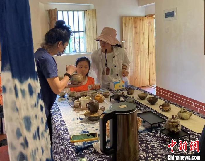 圖為：游客正在咨詢臺(tái)灣柴燒作品。　葉秋云 攝
