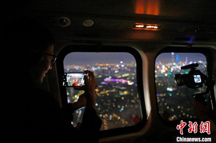 6月3日晚，游客乘坐上海新空直升機(jī)有限公司直升機(jī)開啟鳥瞰黃浦江空中圓夢之旅，并用手機(jī)拍攝城市夜景?！∫罅⑶?攝