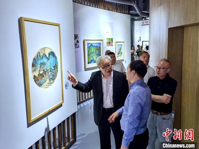 海峽兩岸藝術(shù)家畫展上，藝術(shù)家進(jìn)行藝術(shù)交流?！「毒窜?攝