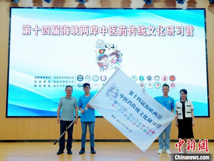 共青團(tuán)福建省委副書記吳雪(右一)、福建中醫(yī)藥大學(xué)黨委副書記林羽(左一)為兩岸學(xué)生代表頒授營旗。　許燁婷 攝