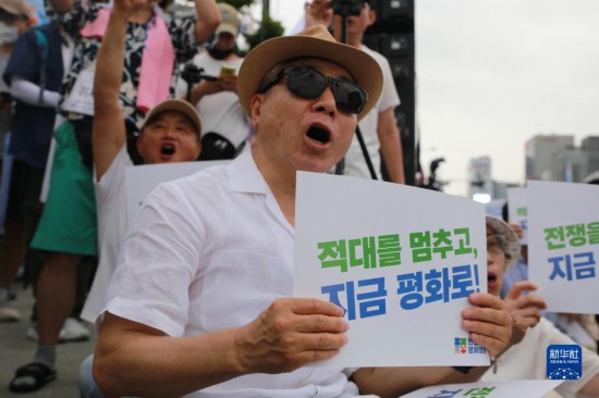 7月22日，在韓國(guó)首爾，人們手舉標(biāo)語(yǔ)參與反戰(zhàn)游行。新華社發(fā)（楊暢 攝）