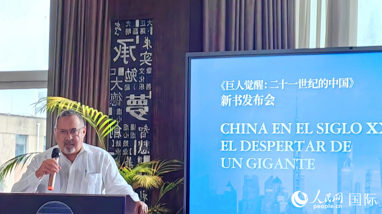 羅德里格斯博士現(xiàn)場介紹著作。吳志華攝