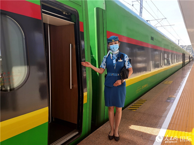 趙瑩靜站在“復(fù)興號(hào)”國(guó)際旅客列車車廂門口歡迎旅客上車。人民網(wǎng) 杜明明攝