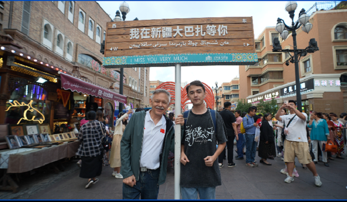 潘維廉和維吾爾族青年伊木蘭“打卡”大巴扎。主辦方供圖