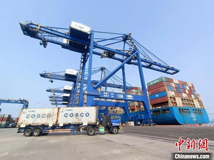 圖為海南洋浦國際集裝箱碼頭，卡車將集裝箱從后方堆場運往碼頭裝卸區(qū)?！堅潞?攝