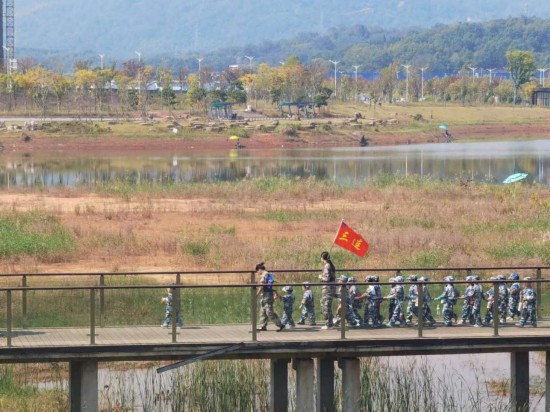 　　10月24日，秋游的幼兒園小朋友在老師帶領(lǐng)下走在清水塘公園里的木橋上。本報記者 常雯宜攝