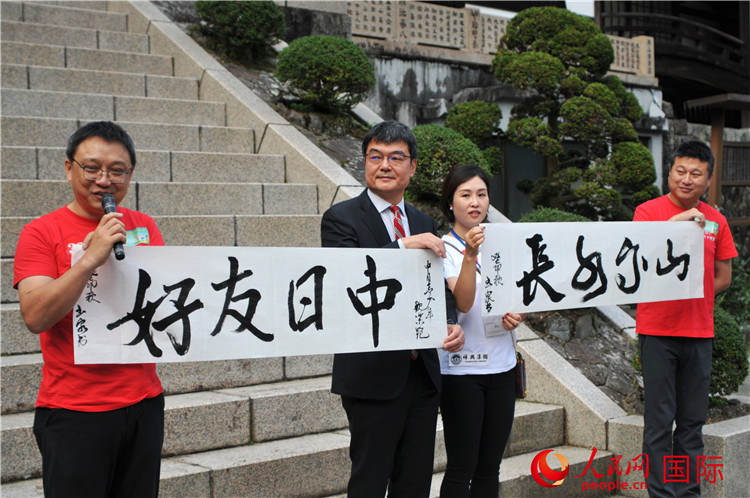 東京中國文化中心主任羅玉泉展示其為本次活動(dòng)書寫的題詞“中日友好，山高水長”。人民網(wǎng) 蔣曉辰攝