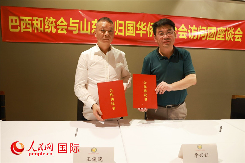中國僑聯(lián)副主席、山東省僑聯(lián)主席李興鈺（右）與巴西和統(tǒng)會會長王俊曉簽署合作協(xié)議書。人民網(wǎng)記者 陳海琪攝