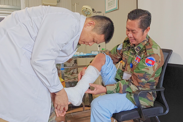 中國第22批赴黎維和醫(yī)療分隊軍醫(yī)為患者打石膏固定患肢。李清竹攝