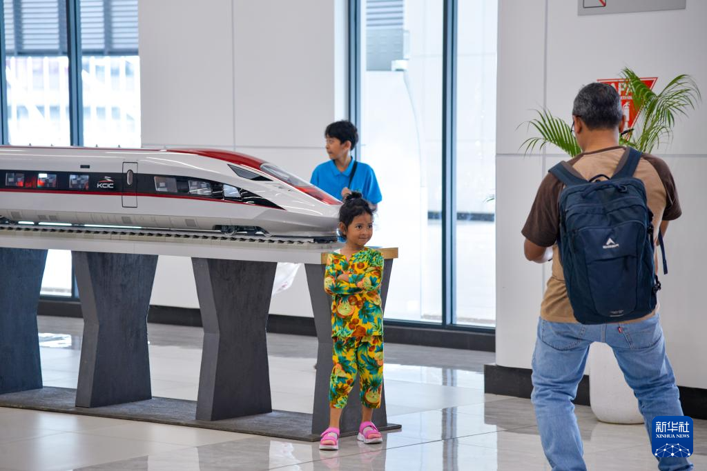 1月24日，在印度尼西亞雅加達(dá)哈利姆站候車大廳，一名小朋友和雅萬高鐵高速動(dòng)車組模型合影。新華社記者 徐欽 攝