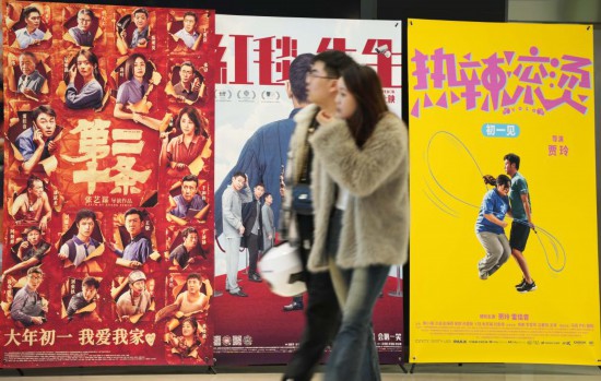 這是2月17日，在沈陽一家影院，觀眾從海報前經(jīng)過。新華社記者李鋼攝