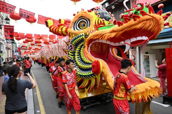 2月1日，由馬來西亞和中國的100多名青少年組成的舞龍隊在馬來西亞馬六甲市雞場街上共舞一條近200米的“長龍”。這是活動現(xiàn)場的“長龍”。新華社記者程一恒攝