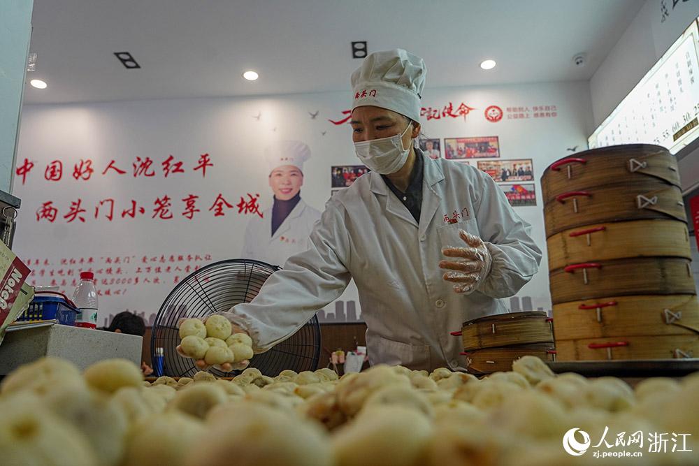 3月31日，在浙江省嵊州市甘霖鎮(zhèn)，嵊州小吃從業(yè)者沈紅平把蒸熟的小籠包晾涼，打包冷藏售賣(mài)。人民網(wǎng) 章勇濤攝