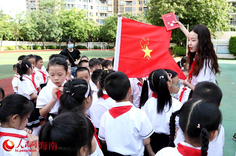老師向少先隊(duì)員展示隊(duì)旗。人民網(wǎng) 符武平攝