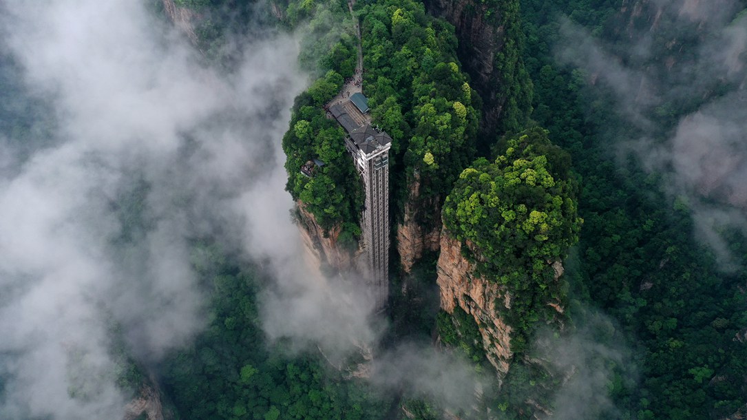 位于張家界武陵源景區(qū)的百龍?zhí)焯蓁偳对谠旗F繚繞的峰林間，雄偉壯觀。吳勇兵攝