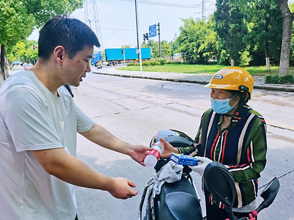 何超為過路的老人送上礦泉水和冷飲。人民網(wǎng)記者 王繼亮攝
