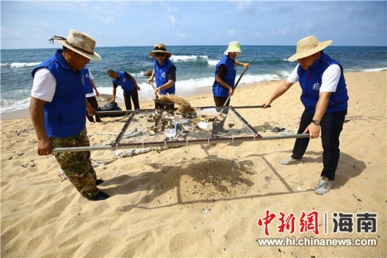 環(huán)保志愿者用篩網(wǎng)“淘”出海灘上的垃圾。
