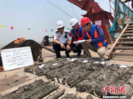 圖為勘察設(shè)計(jì)人員與海事局工作人員查看巖芯情況?！∥赫?攝