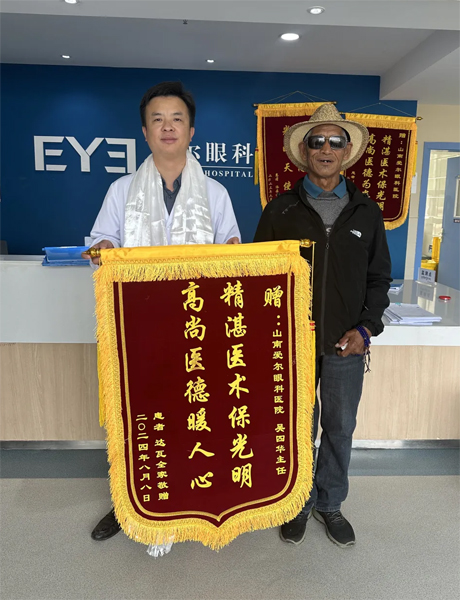 達(dá)瓦老人向吳四華（左）贈(zèng)送錦旗。受訪者供圖