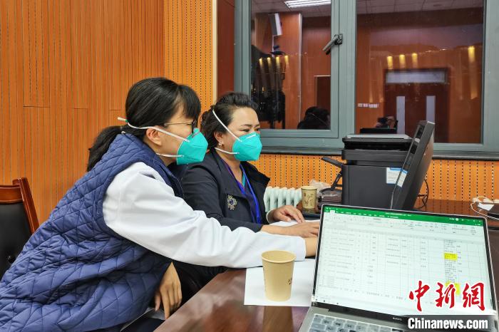 8月9日，楊蘇喬(左)在拉薩方艙醫(yī)院指揮部讀取艙內(nèi)患者胸部CT?！∈茉L者供圖