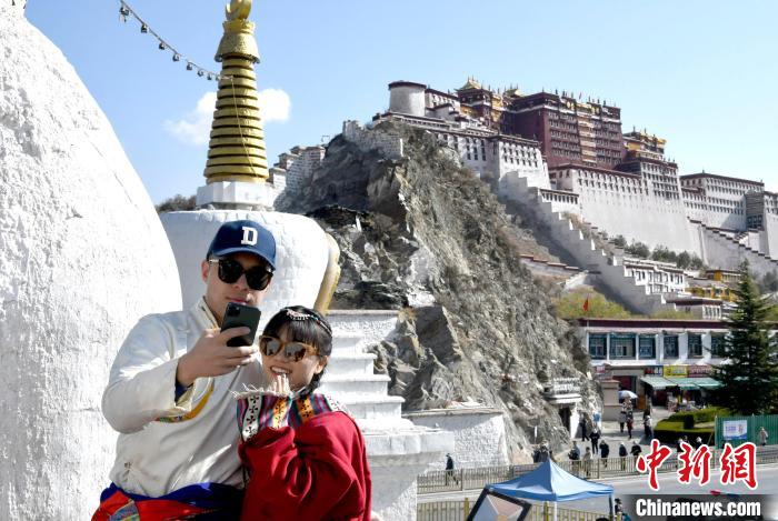 4月17日，游客身著藏式元素服裝在拉薩布達(dá)拉宮觀景臺(tái)拍照留念?！±盍?攝