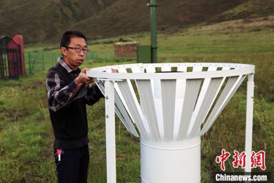 圖為班瑪縣氣象局工作人員在維護(hù)藏雪茶基地氣候站。青海省氣象局供圖