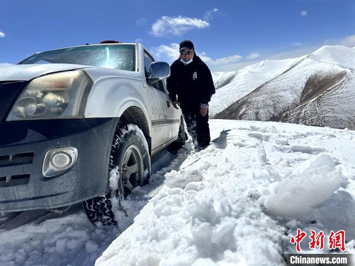 圖為生態(tài)管護人員準備在雪地推車?！《“瓦_杰 攝