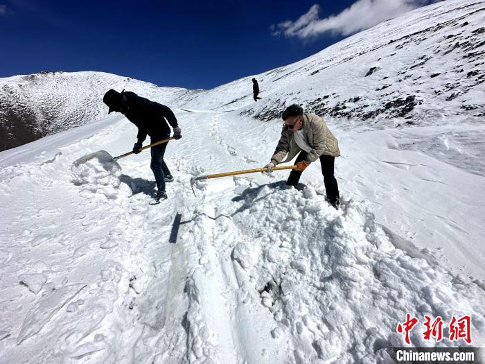 圖為生態(tài)管護人員在巡護道路上清雪。　丁巴達杰 攝