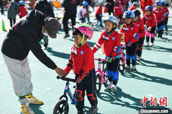圖為拉薩市實(shí)驗(yàn)幼兒園孩子們在教練的指導(dǎo)下練習(xí)滑步車。　何蓬磊 攝