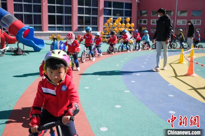 圖為拉薩市實(shí)驗(yàn)幼兒園孩子們在教練的指導(dǎo)下練習(xí)滑步車?！『闻罾?攝