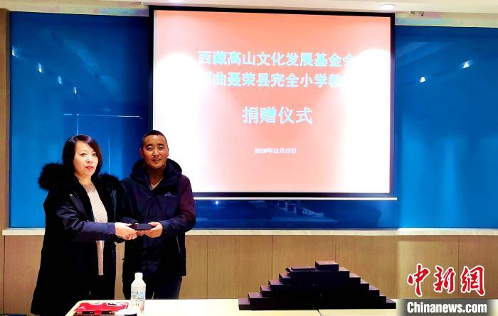 圖為西藏高山文化發(fā)展基金會理事長溫麗向聶榮縣完全小學(xué)負(fù)責(zé)人捐助儀器?！∮谫e 攝