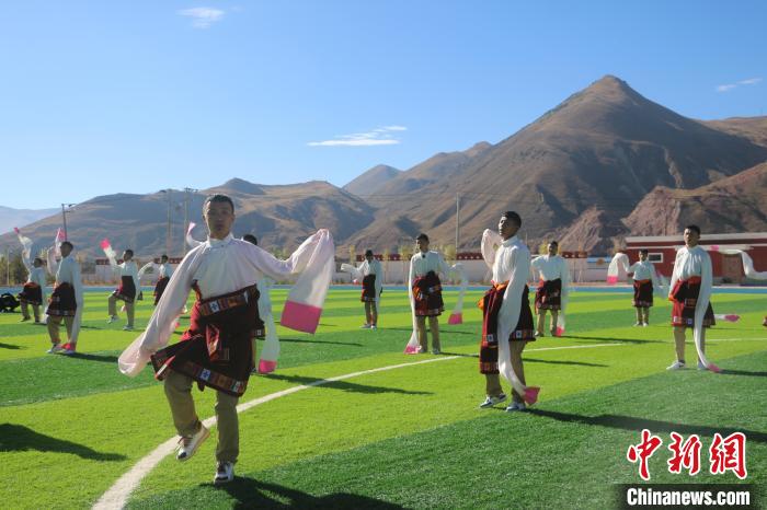 圖為青海師范大學(xué)附屬玉樹實驗學(xué)校學(xué)生在綠茵場跳起囊謙古舞—卓根瑪。　程雨 攝