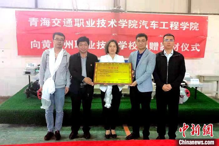 圖為李富香(中)代表學(xué)校為州縣技校捐贈器材。(資料圖) 青海省教育廳供圖