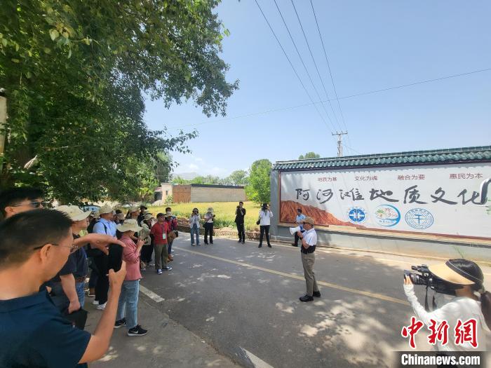 圖為中國地質(zhì)大學(xué)(北京)教授張緒教介紹村落情況?！『衍?攝