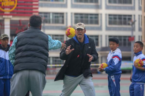 在高原上教孩子們打手球，“慢慢兒來(lái)，甭著急！”