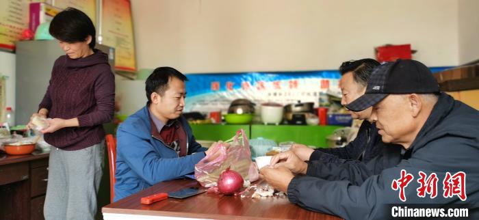圖為扶貧路上“臨時(shí)一家人”準(zhǔn)備午餐?！∥航ㄜ?攝