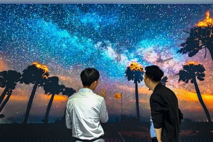 長(zhǎng)春光博會(huì)希達(dá)電子展區(qū)，一位工作人員正在給一位觀眾講解。（長(zhǎng)春新區(qū)供圖）