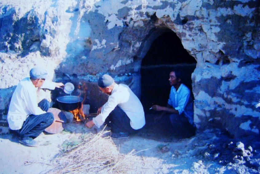 1983年，“六老漢”一代治沙人在“地窩子”生活做飯。新華社發(fā)（八步沙林場供圖）