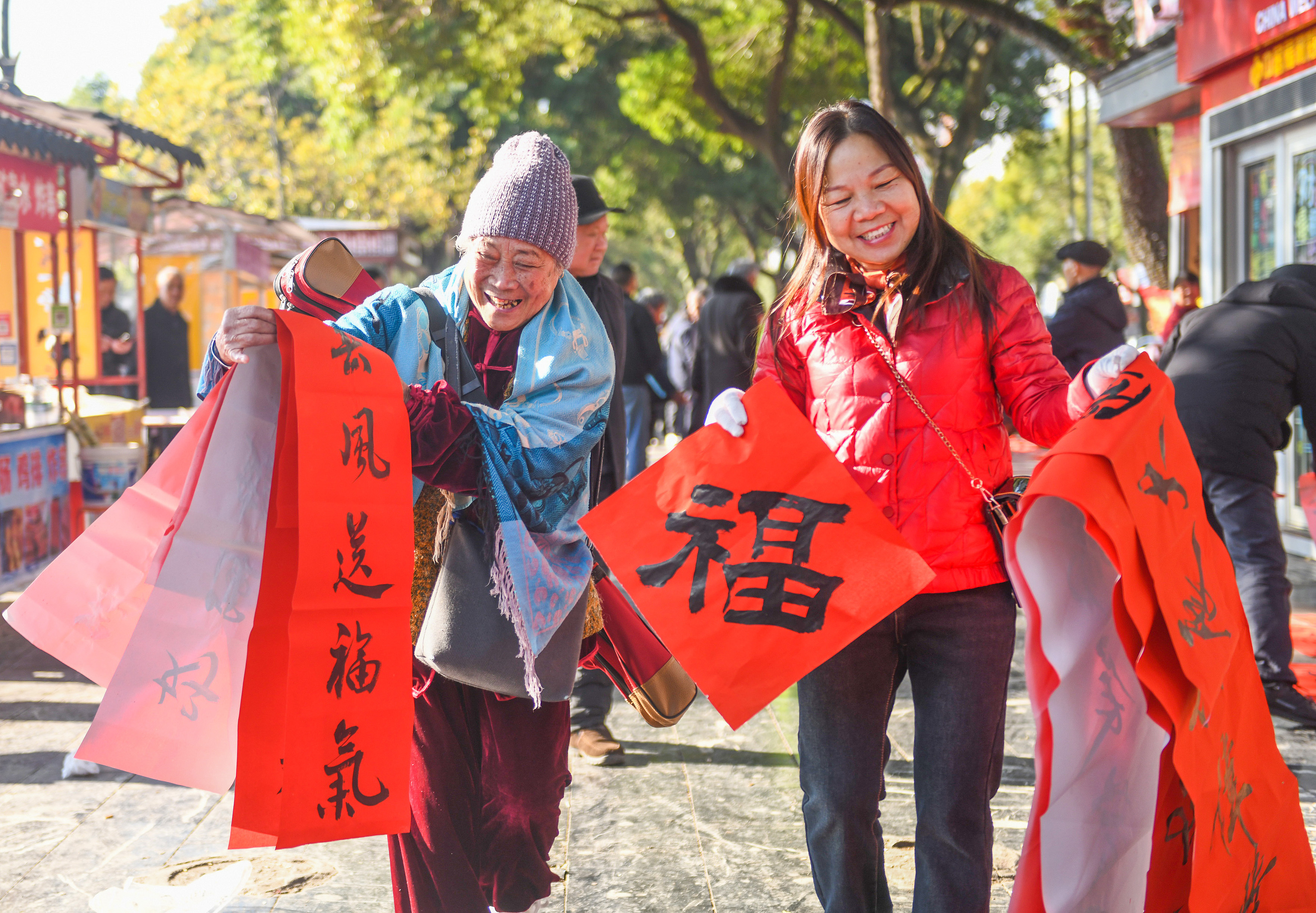 2025年1月13日，在湖南省永州市道縣西洲公園義工崗亭，市民們領到了書法志愿者為大家書寫的春聯(lián)。