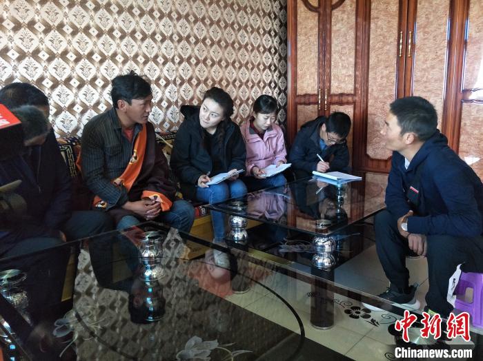 圖為調(diào)查組工作人員正在入戶調(diào)查?！∑钤鲚?攝