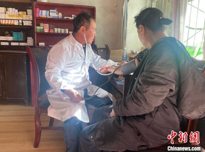 索木滾(左)為村民看病?！∪捞量h委宣傳部供圖