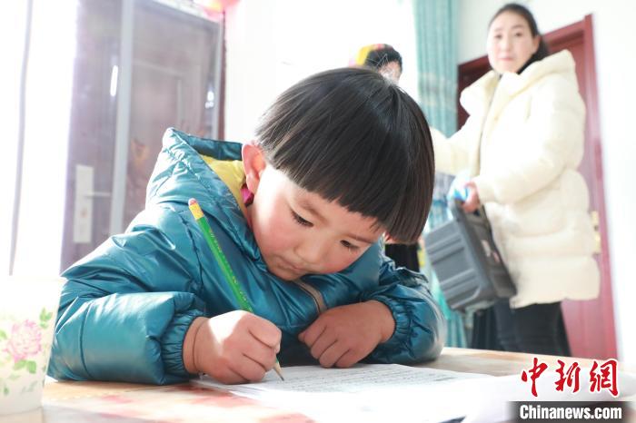 孩子們?cè)诩议T口上學(xué)，是楊周馬草搬入蘭州新家最為開心的事情。小女兒楊洋正在學(xué)習(xí)寫數(shù)字?！∥航ㄜ?攝